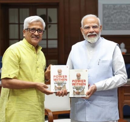 PM signs copy of Dr. R. Balasubramaniam's book 'Power Within The Leadership Legacy of Narendra Modi'