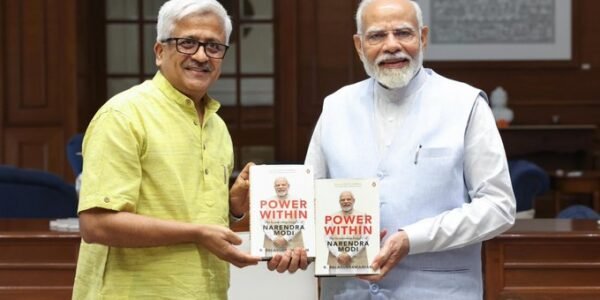 PM signs copy of Dr. R. Balasubramaniam's book 'Power Within The Leadership Legacy of Narendra Modi'